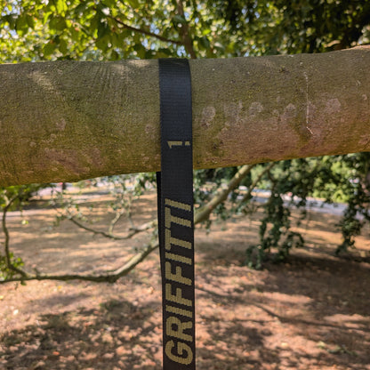 GRIFFITTI Nylon-Gurt liegt als Schlaufe über einem horizontal verlaufenden Ast